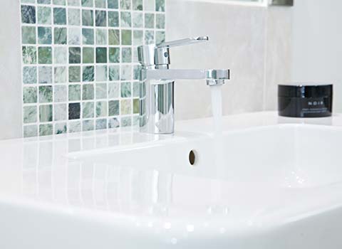 Property Interior - Bathroom basin with water flowing from tap