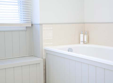 Property Interior - bathroom with bath next to a window with blinds